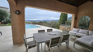 Eine Terrasse im Freien mit Pool, Tisch mit Stühlen und einer Sitzecke.