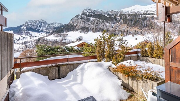 A snowy mountain landscape with a wooden deck and a wooden fence. - Loges A : Grande terrasse à 50m des pistes. (LE GRAND BORNAND)