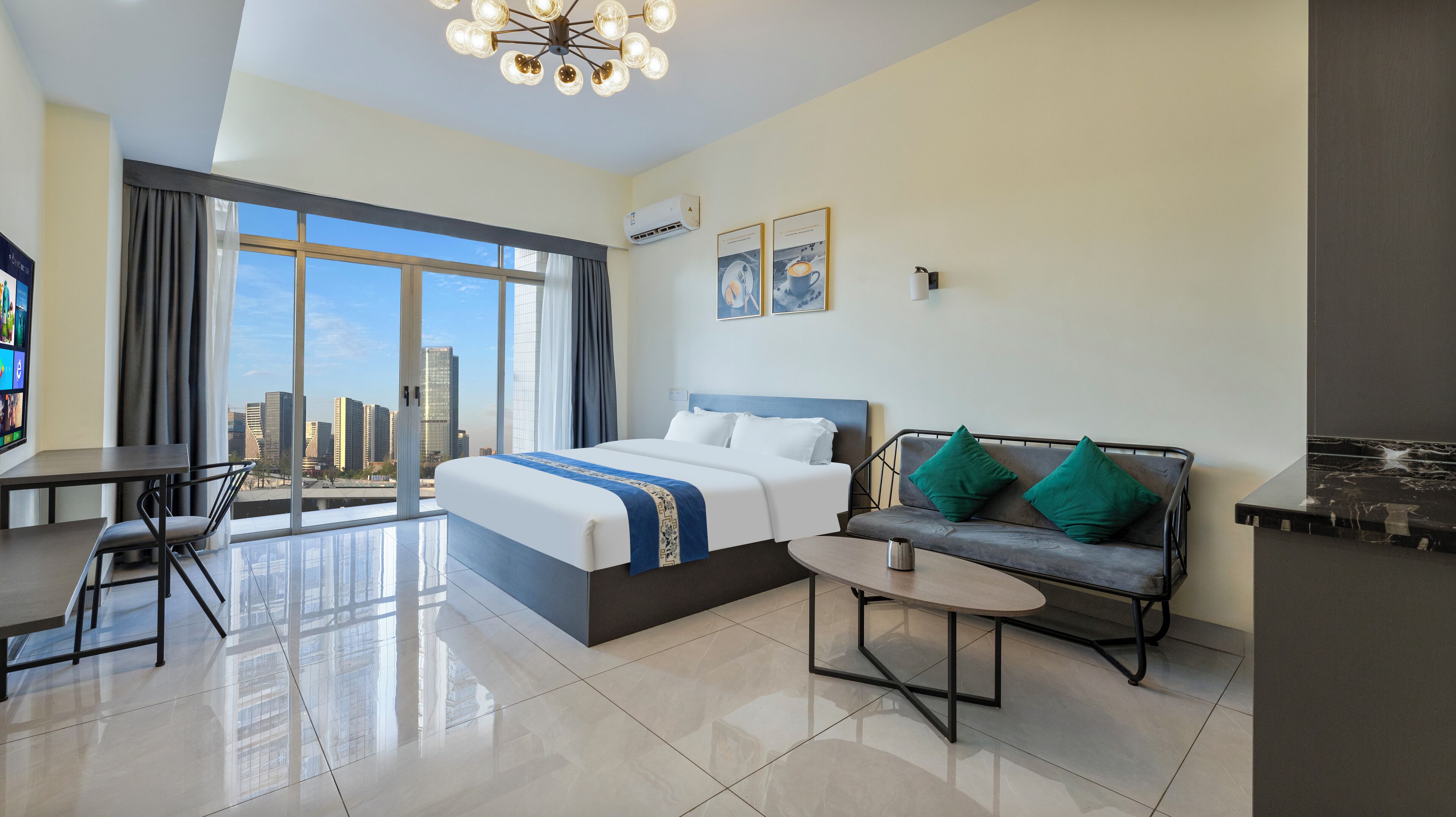 A hotel room with a large bed, a sofa, a small table, a TV, and a city view.
