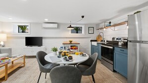 A modern kitchen with a dining area, a TV, and a refrigerator. - Capitol Hill, 3 Apartments, 1 House, Free Parking (Washington)