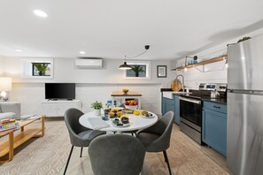 Eine moderne Küche mit Essbereich, Fernseher und Kühlschrank.