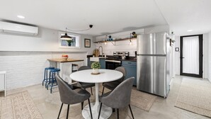 A modern kitchen with a central island, stainless steel appliances, and a dining area with a round table and chairs. - Capitol Hill, 3 Apartments, 1 House, Free Parking (Washington)