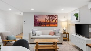 A modern living room with a sofa, coffee table, TV, and artwork. - Capitol Hill, 3 Apartments, 1 House, Free Parking (Washington)