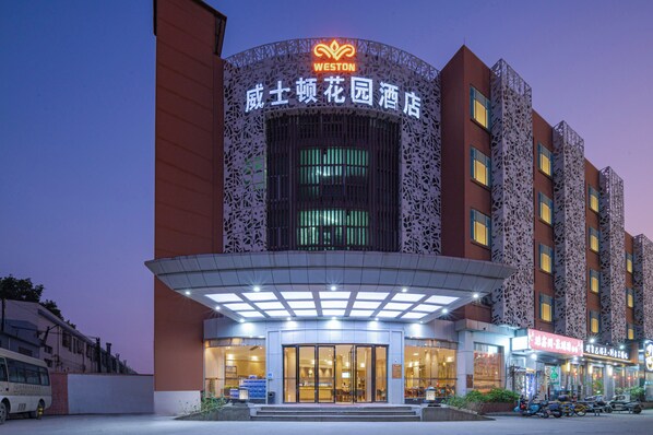 A hotel with a distinctive facade, a large entrance, and a sign indicating it is a WESTON hotel. - Weston Coastal Hotel Bao'an Intl Airport (Shenzhen)