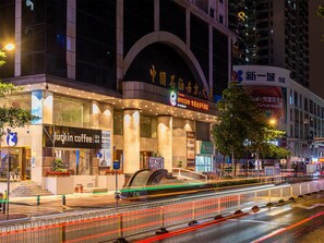 A modern building with a prominent entrance, a coffee shop named 'Harkin Coffee' on the ground floor, and a large sign with Chinese characters above the entrance. - Ramada Encore International Hotel Jiangnanxi Metro Station Branch - Free Shuttle Bus to Canton Fair Complex During Canton Fair Period (Guangzhou)