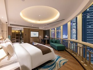 A modern hotel room with a large bed, a seating area, a TV screen, and a city view. - Ramada Encore International Hotel Jiangnanxi Metro Station Branch - Free Shuttle Bus to Canton Fair Complex During Canton Fair Period (Guangzhou)