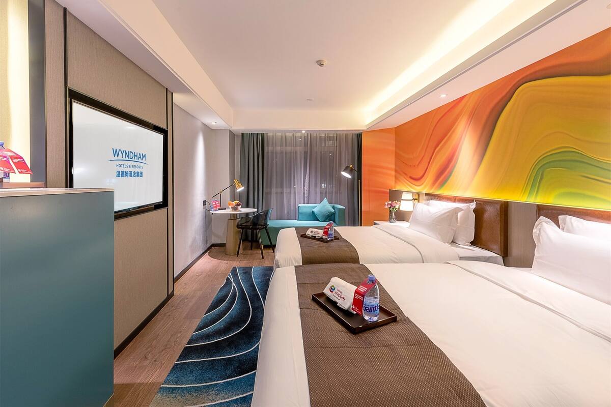 Ein Hotelzimmer mit Bett, Schreibtisch, Sessel, Sofa und einem großen Wandbild.