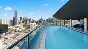 A rooftop pool with a cityscape view, glass railings, and modern architecture. - Alfred Apartments by Arvia Living (Fortitude Valley)