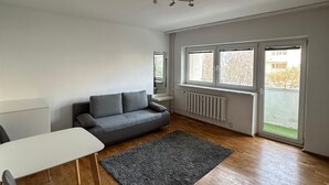 A spacious living room with a grey sofa, a white table, and a grey rug. - Perfect for City Break (Warsaw)