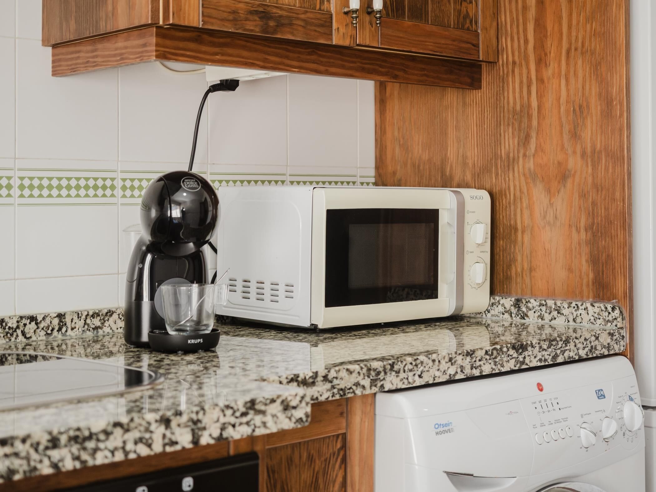 Une cuisine équipée d’une machine à café, d’un four à micro-ondes et d’un lave-vaisselle.