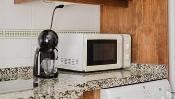 Une cuisine équipée d’une machine à café, d’un four à micro-ondes et d’un lave-vaisselle.