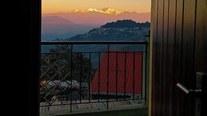 Ein Balkon mit Blick auf ein Bergmassiv bei Sonnenuntergang.