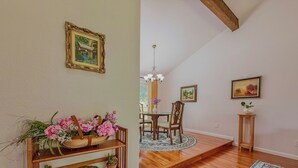 A dining area with a wooden table, chairs, and a chandelier. - Entire 3-bedroom charming house in Lake Forest Park (Lake Forest Park)
