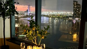 Une table décorée de bougies, avec vue sur une ville au crépuscule.
