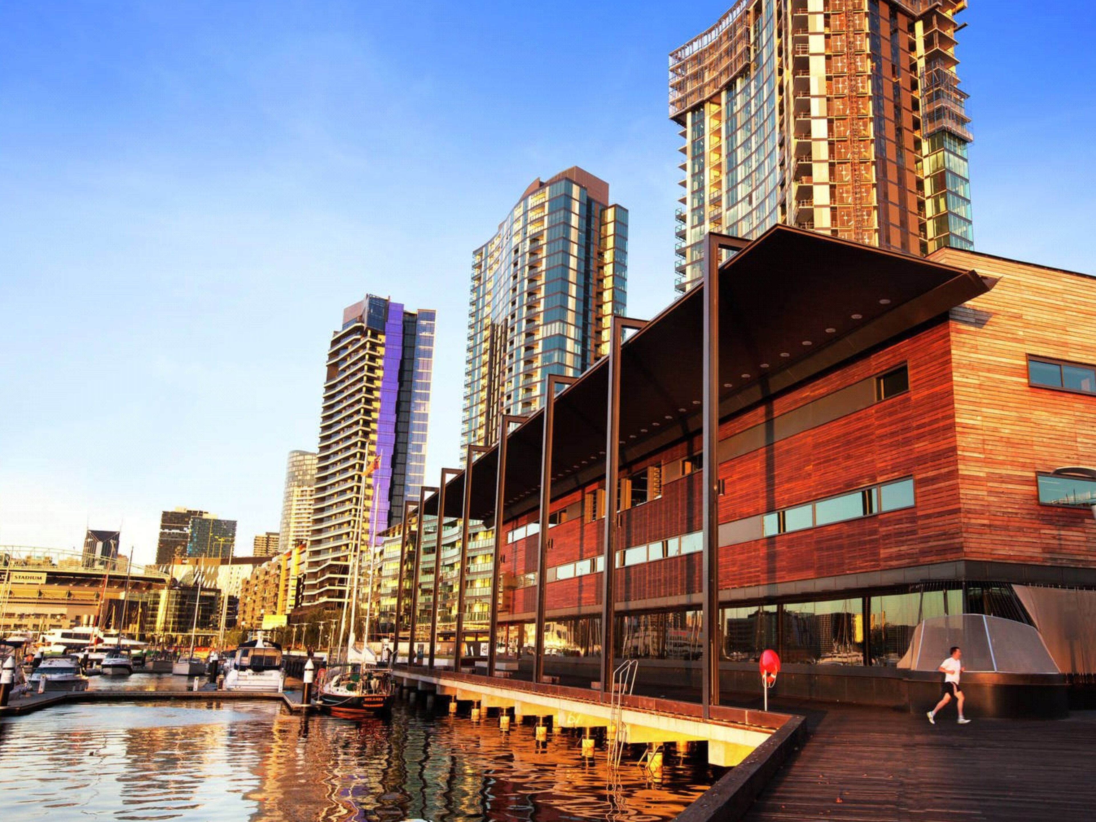 Un edificio moderno frente al agua, con fachada de madera y amplios ventanales.