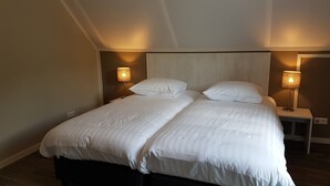 A double bed with white linens in a hotel room. - Modern Villa With Garden (Almen)