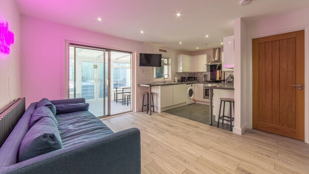 Un apartamento moderno con sala de estar, cocina y balcón.