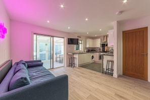 Un apartamento moderno con sala de estar, cocina y balcón.