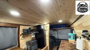 A compact kitchen with a gas stove, a refrigerator, a microwave, and a coffee maker. - Birch Bus in North Pole (North Pole)