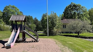 A playground with a slide and stairs, surrounded by grass and trees. - Skolhuset by Interhome (Gullringen)