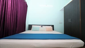 A bed with a blue bedspread, two pillows, and a headboard. - Sanjana The Luxurious Family Stay 2 (Karkala)