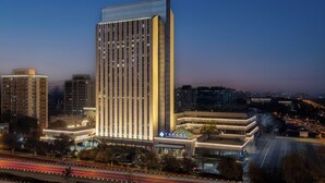 Ein hoch aufragendes Hotel mit modernem Design, gekennzeichnet durch eine markante vertikale Struktur und eine Glasfassade.