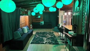 A cozy living room with a dark-colored sofa, a wooden coffee table, and a green patterned rug.