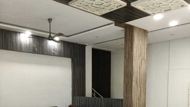 Een moderne woonkamer met een hoekbank, een salontafel en een grote spiegel.