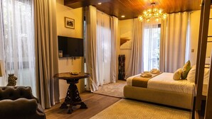 Ein gemütliches Schlafzimmer mit Bett, Fernseher und einem kleinen Tisch.