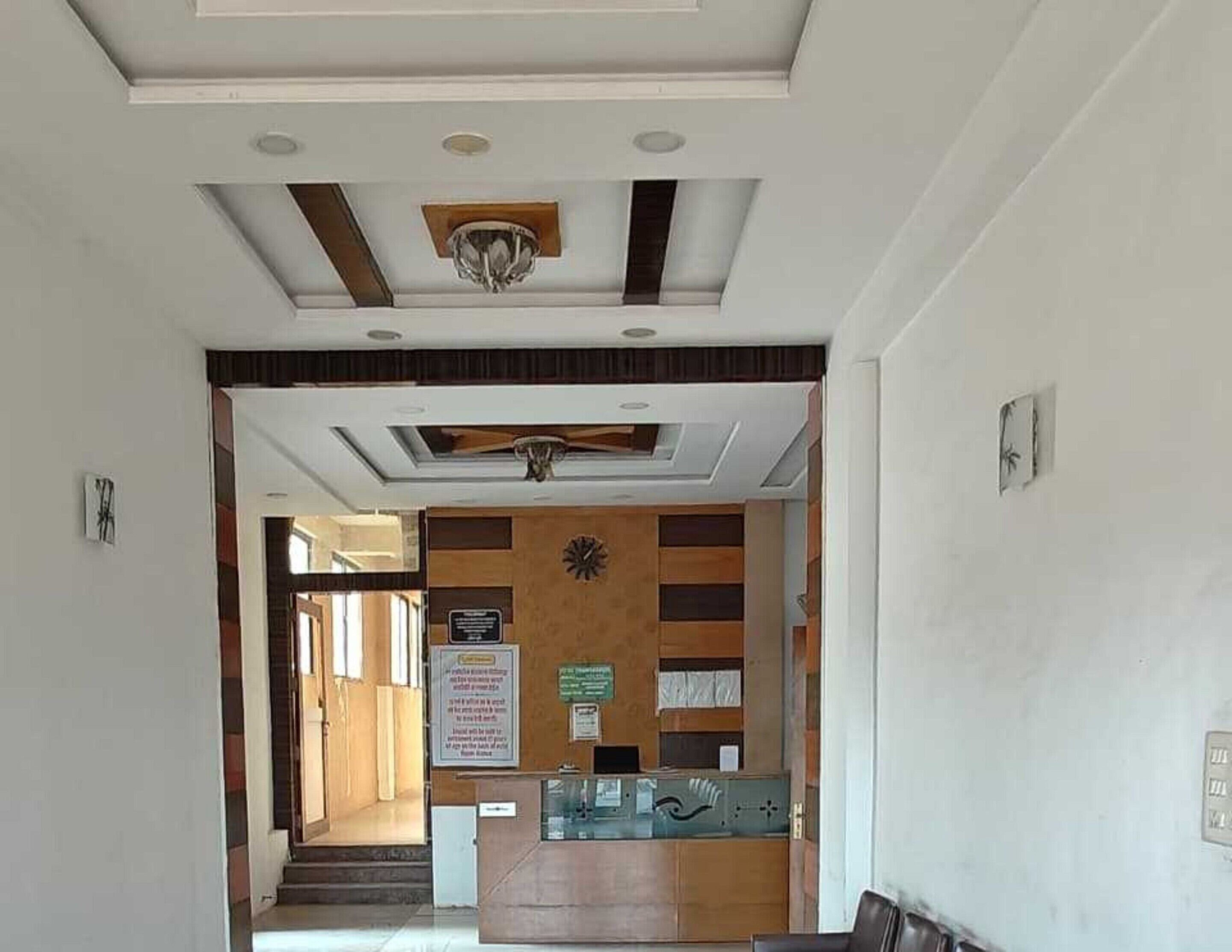 A reception area with a wooden reception desk, a clock, and a ceiling fan.
