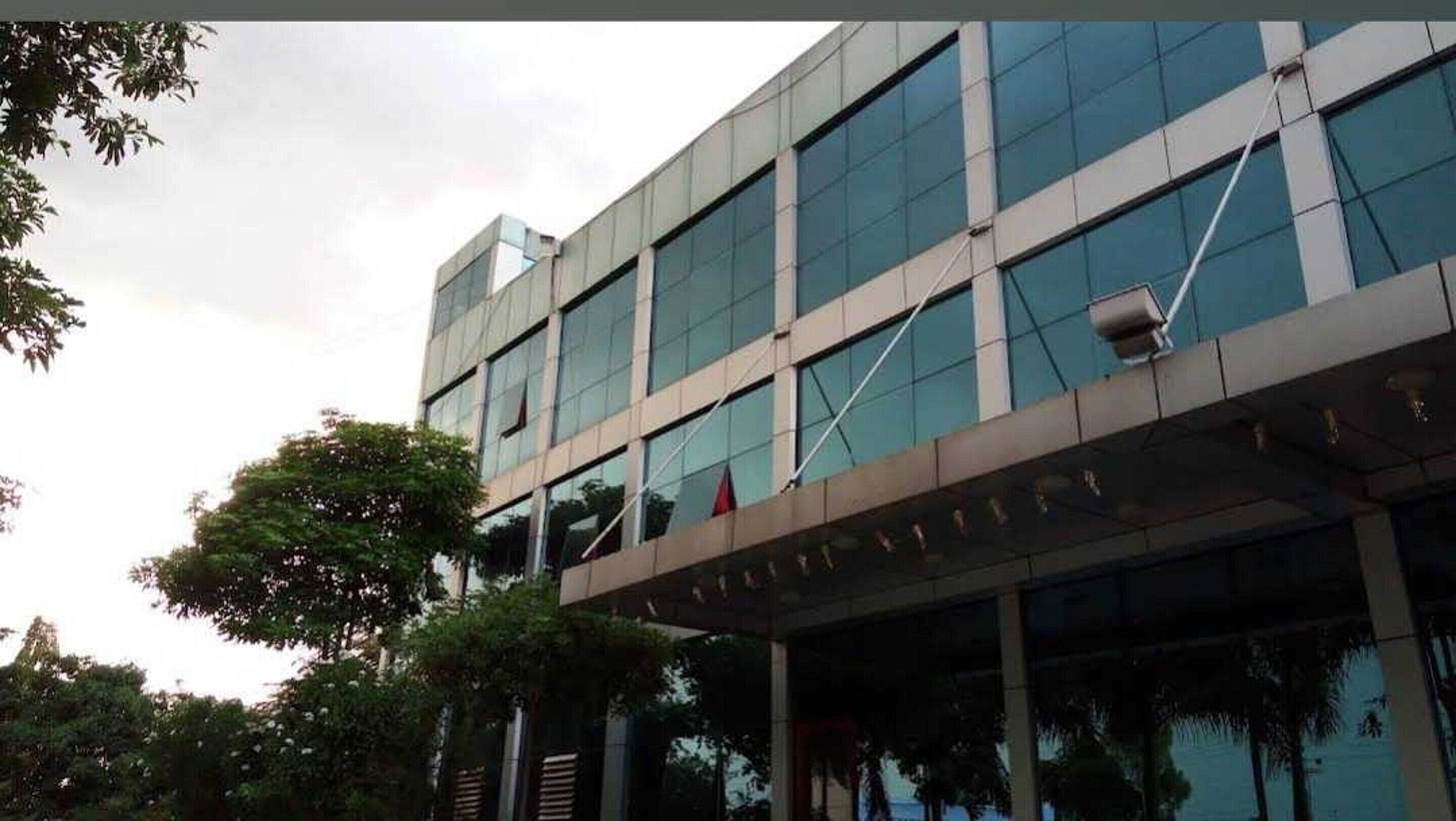 A modern building with multiple floors, large windows, and a flat roof.