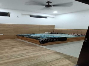 A bedroom with a bed, a ceiling fan, and a window. - Hotel Maa Karni Darbar (Bikaner)