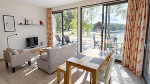 Una sala de estar moderna con sofá, televisión y mesa de comedor.