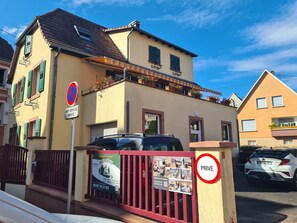 Un immeuble de deux étages doté d’un balcon, d’un panneau indiquant qu’il est interdit de se garer et d’un panneau indiquant qu’il s’agit d’une propriété privée.