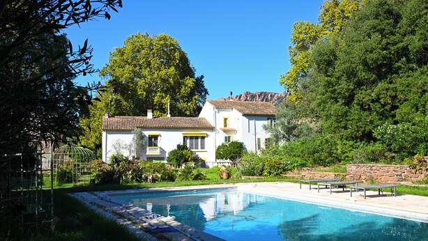 A large swimming pool with a house in the background.