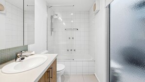 Et moderne badeværelse med bruser, toilet og vask.