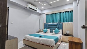 Um quarto moderno com cama, mesas de cabeceira, um espelho e uma janela com cortinas.