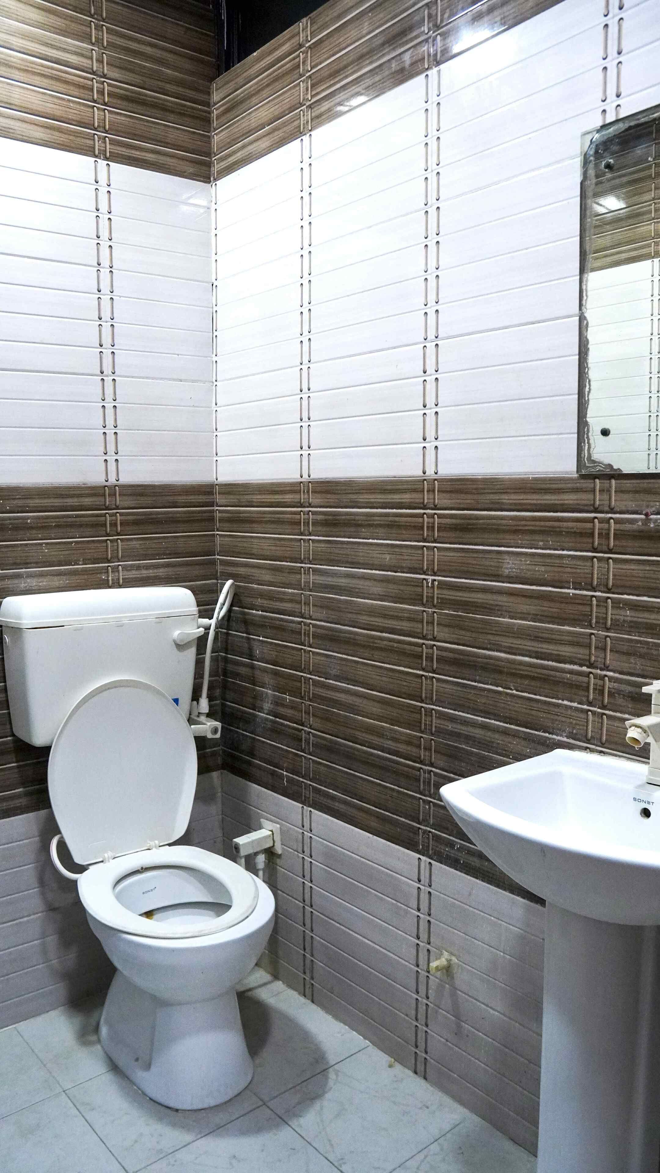 Ein Badezimmer mit Toilette, Waschbecken und gefliesten Wänden.