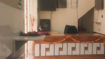 A reception desk with a wooden counter and a chair, decorated with garlands.