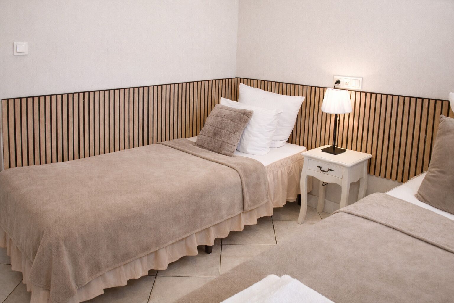 Ein Zimmer mit einem Bett, einem Nachttisch und einer Lampe.