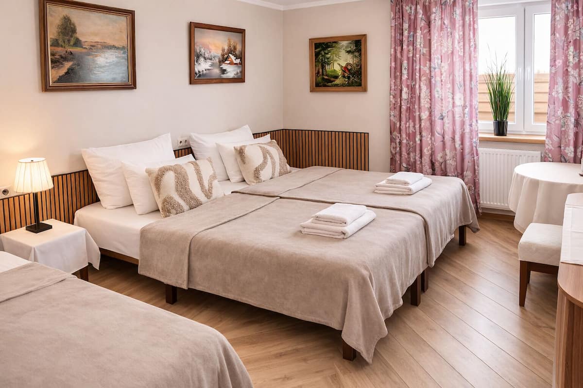 Une chambre d’hôtel avec un lit, des tables de chevet, une lampe et des œuvres d’art accrochées aux murs.