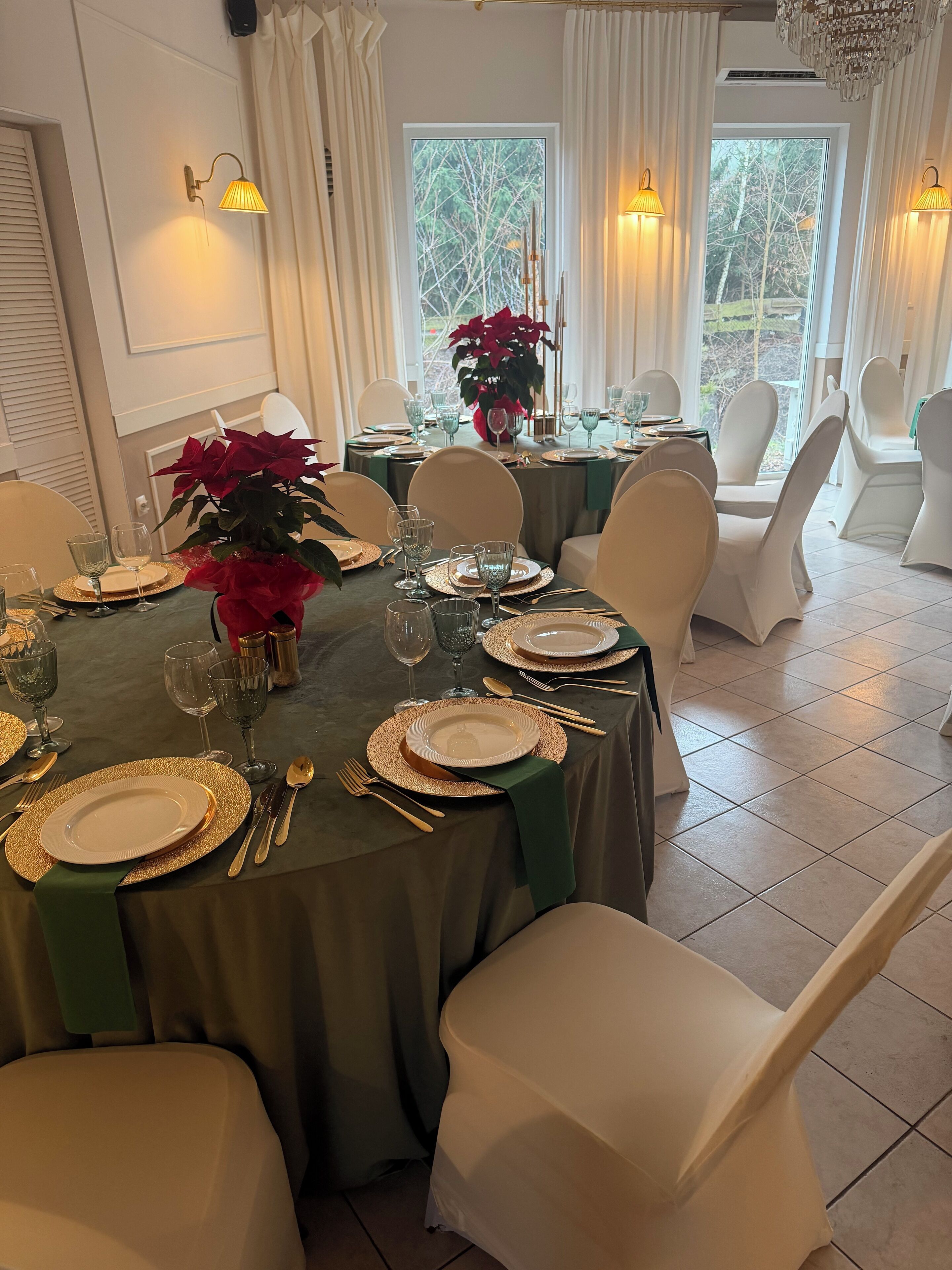 A dining area with a table set for a meal, chairs, and a chandelier.