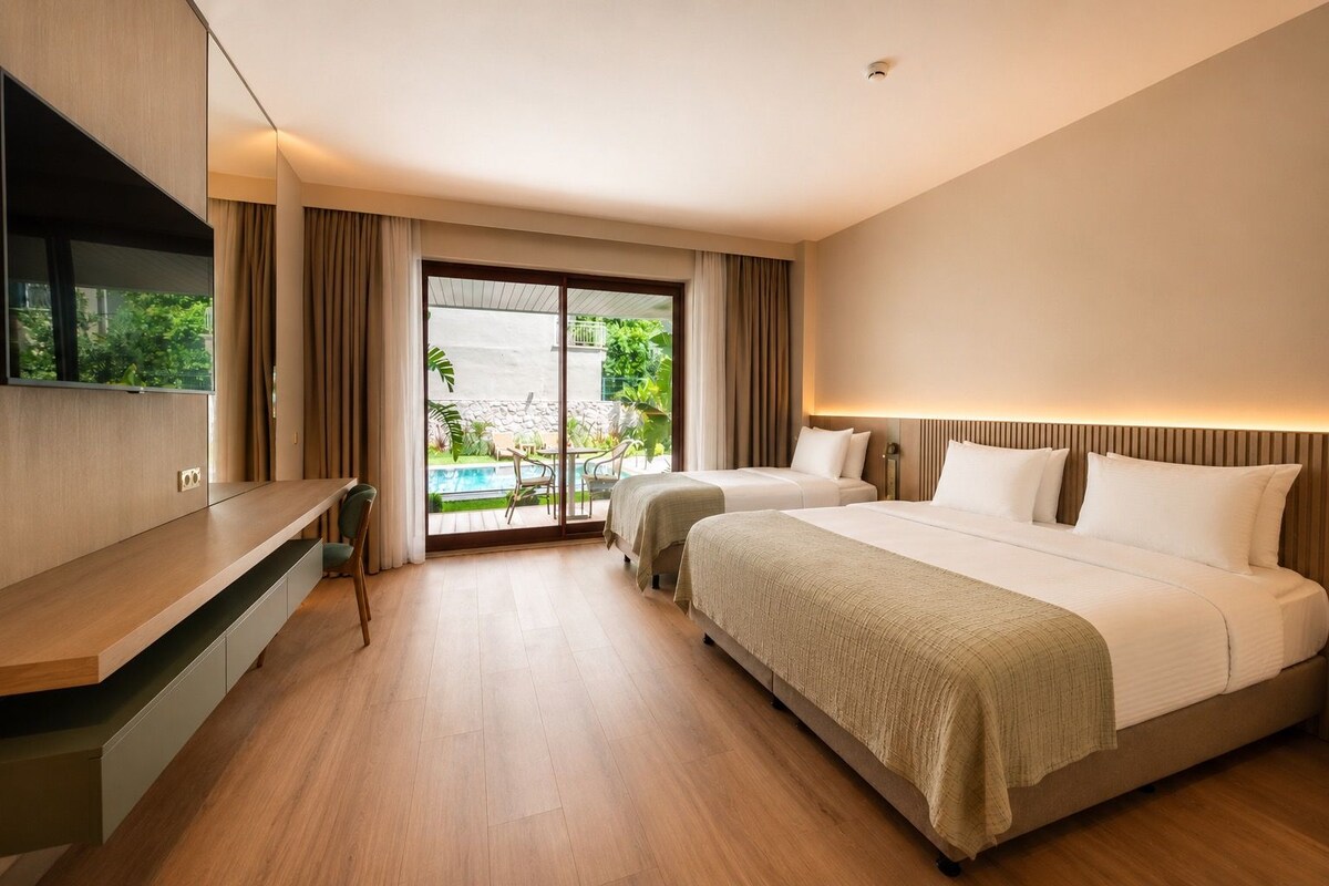 A hotel room with a large bed, a TV mounted on the wall, a desk, and a sliding glass door leading to a pool area.