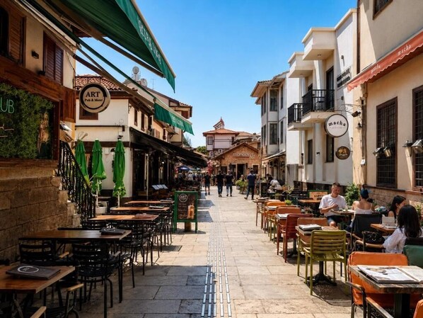 Eine enge Straße mit Außenplätzen, Cafés und Restaurants.