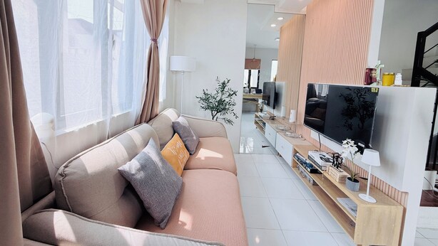 A modern living room with a sofa, TV, and a wooden console table.