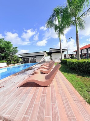 A poolside area with lounge chairs and a swimming pool.