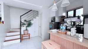 A modern kitchen with a wooden island, stainless steel appliances, and a potted plant.