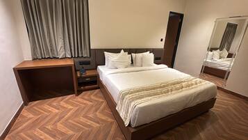 Una habitación de hotel con cama, mesita de noche y espejo.