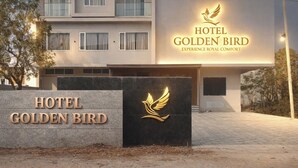 Het uiterlijk van Hotel Golden Bird, met een opvallend bord en een vleugellogo.