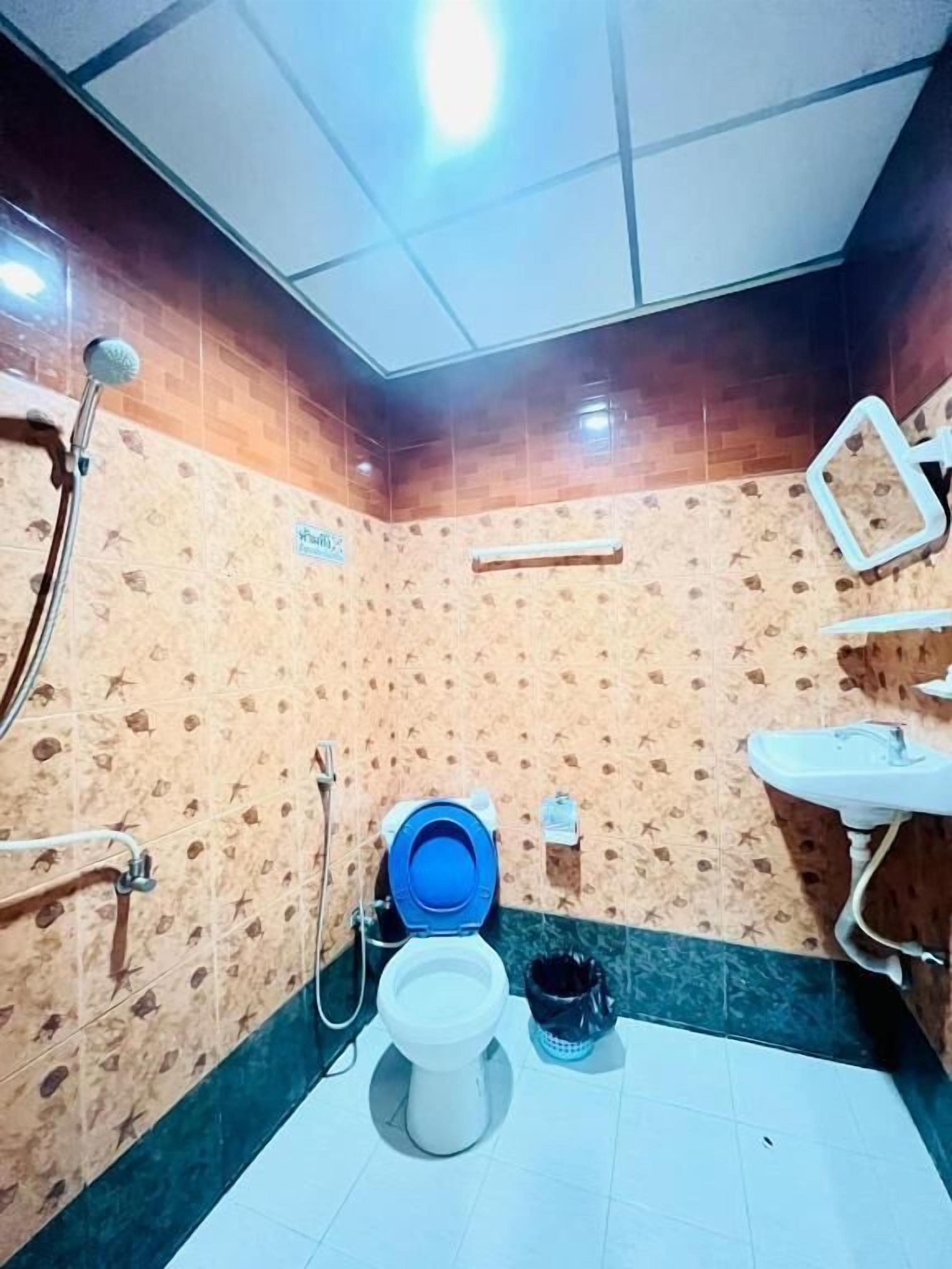 A bathroom with a toilet, shower, and sink.
